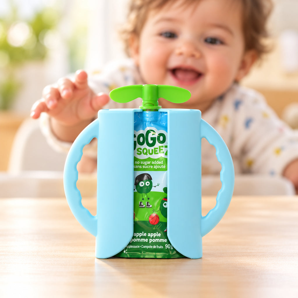 A light blue baby bottle carrier with integrated side handles and a green flip-top lid, holding a green and blue 'oko squeeze' juice pouch, photographed against a neutral light gray background.